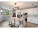 Bright kitchen with white cabinetry, stainless steel appliances, and a large island with seating for four, complemented by modern lighting at 2604 N 27Th St # 4, Phoenix, AZ 85008