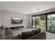 Inviting living room with a comfortable gray sofa, media center, and sliding glass doors opening to a well-manicured backyard at 2604 N 27Th St # 4, Phoenix, AZ 85008