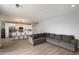 Open-concept space integrates a living area with a kitchen island, white cabinetry, stainless appliances, and a large gray sofa at 2604 N 27Th St # 4, Phoenix, AZ 85008