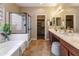 Bathroom with a soaking tub, a glass-enclosed shower, double sinks, and a walk-in closet at 2736 E Sourwood Dr, Gilbert, AZ 85298