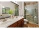 Stylish bathroom featuring a double vanity, framed mirror, and glass-enclosed shower with decorative tile at 2736 E Sourwood Dr, Gilbert, AZ 85298
