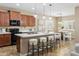 Kitchen with a large center island, seating, dark appliances, and wood cabinets at 2736 E Sourwood Dr, Gilbert, AZ 85298