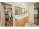 Bright bathroom features a double sink vanity, twin mirrors, and a spacious closet for ample storage at 29110 N 24Th Ln, Phoenix, AZ 85085