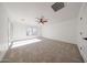 The carpeted bedroom is spacious with a ceiling fan and access to the backyard at 29270 W Weldon Ave, Buckeye, AZ 85396