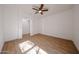 Bright bedroom with light wood-look floors and a ceiling fan, accented by neutral walls and trim at 29270 W Weldon Ave, Buckeye, AZ 85396
