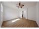Bright bedroom features light wood-look flooring and white walls, complimented by a ceiling fan and natural light at 29270 W Weldon Ave, Buckeye, AZ 85396
