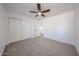 Bright bedroom featuring neutral carpet, a ceiling fan, and ample natural light at 29270 W Weldon Ave, Buckeye, AZ 85396