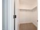 A walk-in closet features built-in shelves and beige carpeting at 29270 W Weldon Ave, Buckeye, AZ 85396