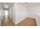 Upstairs hallway featuring neutral walls and trim, wood floors, and interior door at 29270 W Weldon Ave, Buckeye, AZ 85396