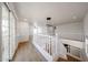 Upstairs hallway featuring light wood-look floors, a staircase, and modern light fixtures at 29270 W Weldon Ave, Buckeye, AZ 85396