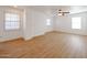 Bright living room featuring wood floors, multiple windows, and a ceiling fan at 29270 W Weldon Ave, Buckeye, AZ 85396