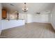 Open-concept living area with light wood-look floors, a breakfast bar, and a ceiling fan at 29270 W Weldon Ave, Buckeye, AZ 85396