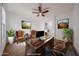 Spacious office with a wooden desk, leather chairs, and a ceiling fan at 29270 W Weldon Ave, Buckeye, AZ 85396