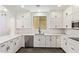 Bright kitchen featuring white cabinets, stainless steel appliances, and dark tile floors at 2947 N Sonoran Hls, Mesa, AZ 85207