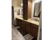 A bathroom with granite countertops, tiled floors, wood cabinets and dual sinks at 29935 W Roosevelt St, Buckeye, AZ 85396