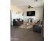 A neutral living room with tile flooring, a ceiling fan, modern furniture, and an entertainment center at 29935 W Roosevelt St, Buckeye, AZ 85396