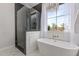 Luxurious bathroom with a glass-enclosed shower, soaking tub, and natural light at 3030 E Camellia Dr, Gilbert, AZ 85296