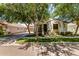 Inviting home with lush trees, verdant grass, and a charming entrance, complete with a tidy driveway and welcoming facade at 3030 E Camellia Dr, Gilbert, AZ 85296