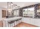 Wet bar area with marble counter, bar seating, open shelving, and stylish decor at 3030 E Camellia Dr, Gilbert, AZ 85296