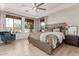 Spacious main bedroom featuring a tray ceiling, ceiling fan, and large windows at 3030 E Camellia Dr, Gilbert, AZ 85296
