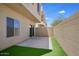 Private backyard featuring artificial turf, concrete patio, block wall, and sliding glass door at 3113 E Danbury Rd # 10, Phoenix, AZ 85032