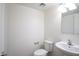 Well-lit half bathroom features a white pedestal sink and toilet and simple vanity lighting at 3113 E Danbury Rd # 10, Phoenix, AZ 85032