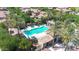Aerial view of the community pool and spa surrounded by lush landscaping and palm trees at 3467 N Hooper St, Buckeye, AZ 85396