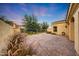 Landscaped backyard featuring pavers, mature landscaping, and elegant wrought iron fence at 3467 N Hooper St, Buckeye, AZ 85396