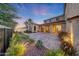 Expansive paver backyard with lush landscaping, including uplighting, creating a picturesque outdoor space at 3467 N Hooper St, Buckeye, AZ 85396