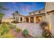 Expansive backyard with brick-paved patio, manicured gardens, and the home's elegant architecture providing a picturesque view at 3467 N Hooper St, Buckeye, AZ 85396