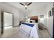 Cozy bedroom with ceiling fan, wood accent headboard, side tables, and tile floors at 3467 N Hooper St, Buckeye, AZ 85396