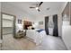 Cozy bedroom with ceiling fan, wood accent headboard, side tables, and tile floors at 3467 N Hooper St, Buckeye, AZ 85396