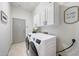 Well-lit laundry room with modern washer and dryer, storage cabinets, and decor at 3467 N Hooper St, Buckeye, AZ 85396