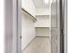 Well-organized walk-in closet with wooden shelving and wood-look tile flooring; access to closet and storage at 3467 N Hooper St, Buckeye, AZ 85396