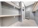 Spacious walk-in closet featuring built-in shelving and plenty of room for storage; neutral colored walls at 3467 N Hooper St, Buckeye, AZ 85396