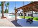 Entertainer's backyard with a covered patio, seating, lush green grass, and a sparkling pool at 3646 W Brown St, Phoenix, AZ 85051