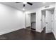 Bright bedroom with a ceiling fan, sliding door closet, dark wood floors, and an open entrance to another room at 3646 W Brown St, Phoenix, AZ 85051