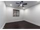 Bright bedroom featuring neutral walls, a ceiling fan, dark wood floors, and a window with natural shades at 3646 W Brown St, Phoenix, AZ 85051