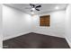 Bright bedroom with a ceiling fan, light-colored brick wall, dark wood floors, and a window with natural shades at 3646 W Brown St, Phoenix, AZ 85051