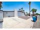 Wide driveway and exterior view featuring desert landscaping, a blue trash receptacle, and palm trees at 3646 W Brown St, Phoenix, AZ 85051