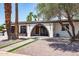 Stunning exterior features a welcoming arched entryway, mature landscaping, and a pristine white facade at 3646 W Brown St, Phoenix, AZ 85051