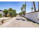 Exterior view of a gated gravel driveway with lush landscaping at 3646 W Brown St, Phoenix, AZ 85051