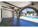 This outdoor living area features an outdoor kitchen, pool, and brick arches at 3646 W Brown St, Phoenix, AZ 85051