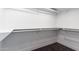 This walk-in closet features built-in shelving and dark wood-look floors at 3646 W Brown St, Phoenix, AZ 85051