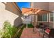 Charming backyard patio featuring comfortable seating, lush plants, and a welcoming shade umbrella at 3783 E Stiles Ln, Gilbert, AZ 85295