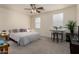 Comfortable bedroom with a ceiling fan, large bed, desk, and carpeted floors at 3783 E Stiles Ln, Gilbert, AZ 85295