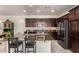 Charming kitchen features an island with seating, granite countertops, and stylish dark wood cabinetry at 3783 E Stiles Ln, Gilbert, AZ 85295