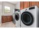 Convenient laundry room with modern washer, dryer, stainless steel fridge, and ample counter space at 3824 E Parkside Ln, Phoenix, AZ 85050