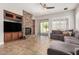 A cozy living room with stone fireplace, large sectional couch, and sliding glass doors to the backyard at 3824 E Parkside Ln, Phoenix, AZ 85050