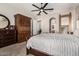 Main bedroom features a beautiful dresser, a ceiling fan and an arched entry to the bathroom at 3824 E Parkside Ln, Phoenix, AZ 85050
